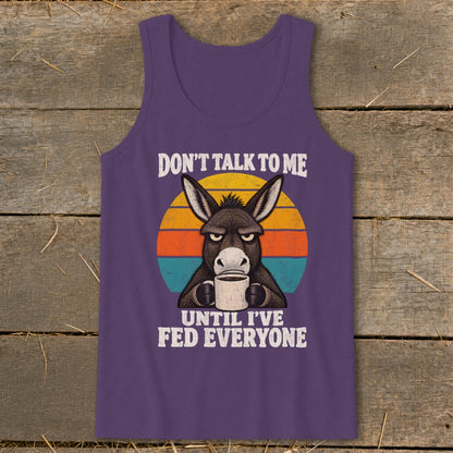 Purple tank top featuring a graphic of a grumpy donkey holding a coffee mug and text reading Don't Talk To Me Until I've Fed Everyone.