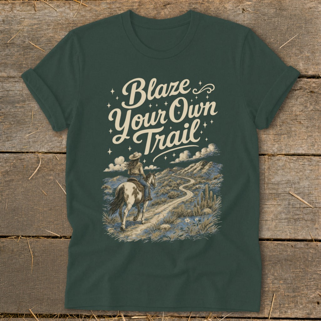 Dark green t-shirt with "Blaze Your Own Trail" graphic featuring a cowgirl on horseback.