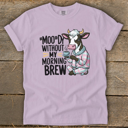 Cow in pajamas holding coffee mug with text "MOO"DY WITHOUT MY MORNING BREW.