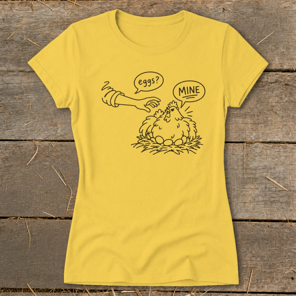 Yellow t-shirt with cartoon of a hen protecting eggs from a reaching hand labeled "eggs?" and "MINE".