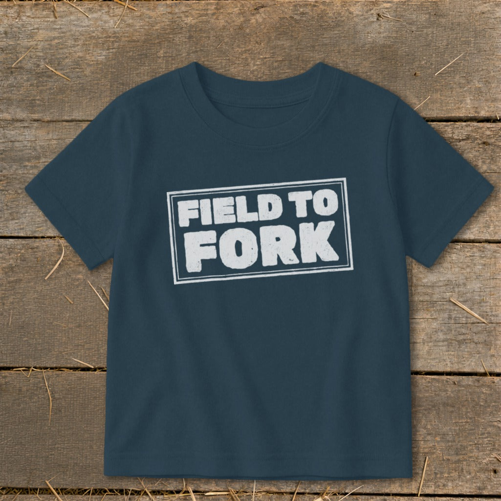 Dark blue short-sleeve t-shirt with a white rectangular border enclosing the text "FIELD TO FORK."