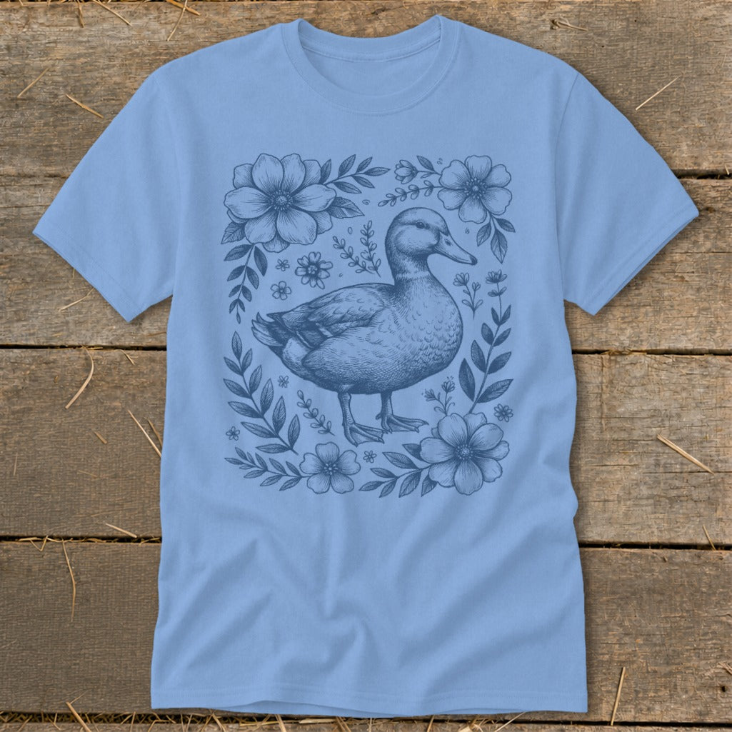 Light blue t-shirt with a detailed blue illustration of a duck surrounded by flowers.