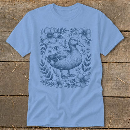 Light blue t-shirt with a detailed blue illustration of a duck surrounded by flowers.