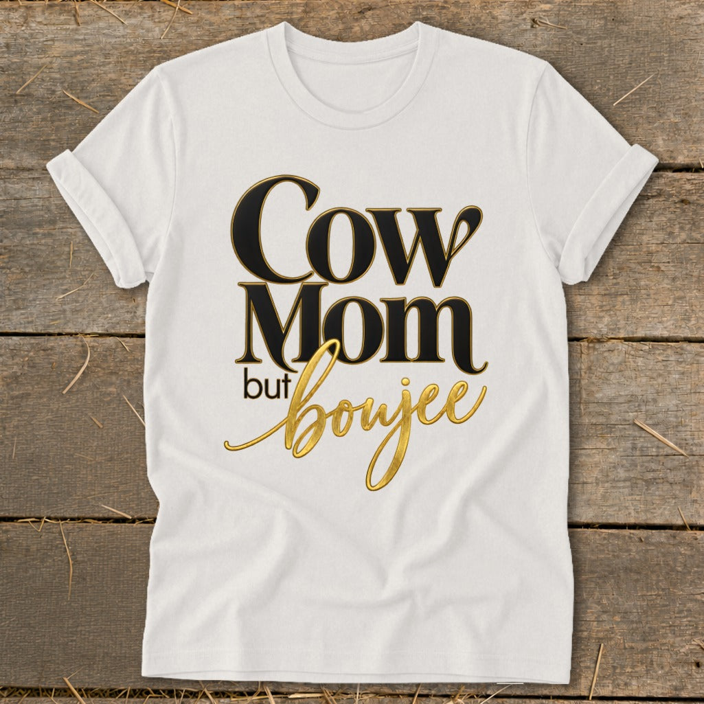 White t-shirt with "Cow Mom but boujee" text in black and gold.