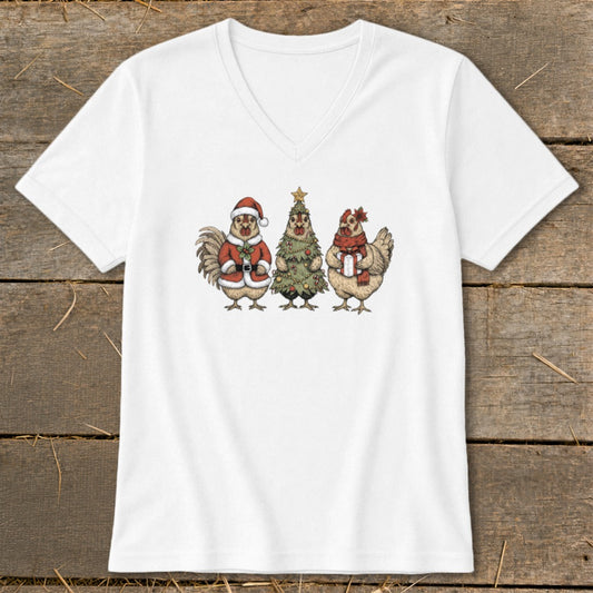 White t-shirt featuring a festive illustration of a rooster in a Santa suit, a Christmas tree, and a hen holding a gift.
