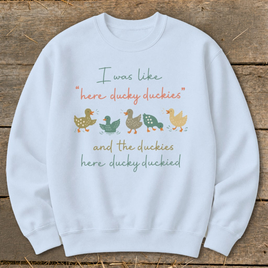 White sweatshirt with ducks and text: "I was like 'here ducky duckies' and the duckies here ducky duckied".