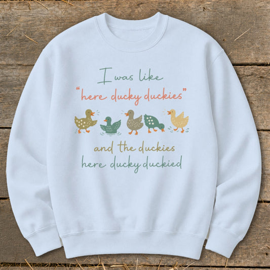 White sweatshirt with ducks and text: "I was like 'here ducky duckies' and the duckies here ducky duckied".
