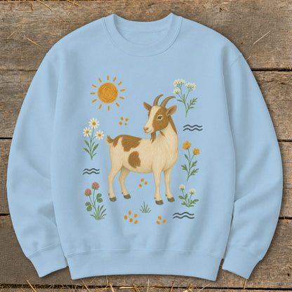 Light blue sweatshirt with a brown and white goat surrounded by flowers and sun.