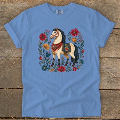 Blue t-shirt with a cream horse surrounded by colorful flowers and leaves.