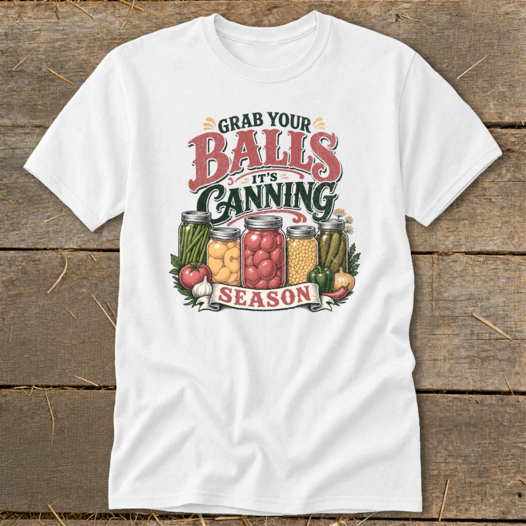 White t-shirt with "Grab Your Balls It's Canning Season" text and jars of preserves.