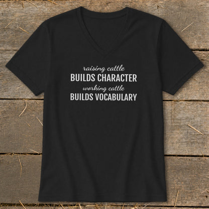 Black v-neck t-shirt with white text: "raising cattle BUILDS CHARACTER, working cattle BUILDS VOCABULARY".
