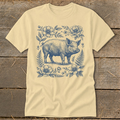 Pig illustration surrounded by flowers and ferns on a cream t-shirt.