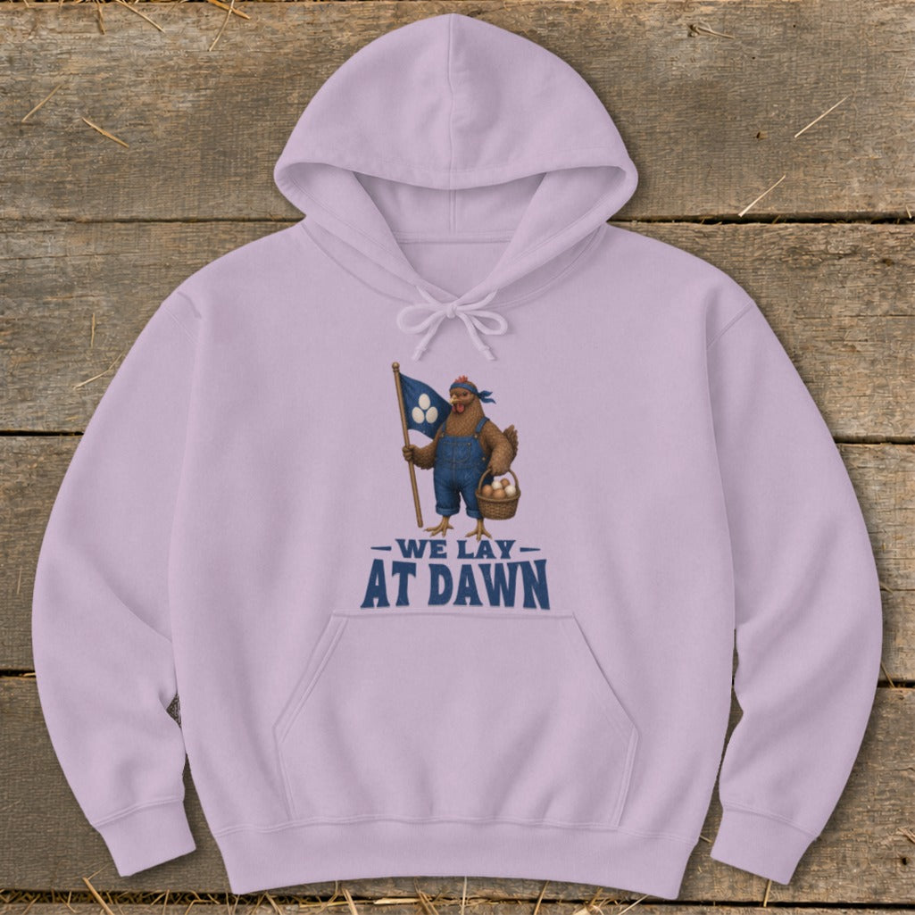 Light purple hoodie with chicken graphic holding flag and basket, text "WE LAY AT DAWN".