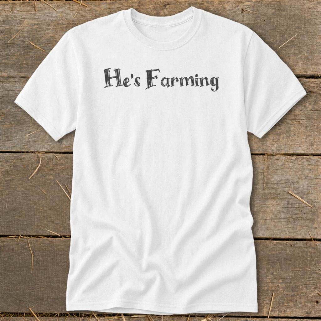 White t-shirt with distressed black text reading "He's Farming."