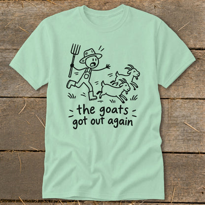 Light green t-shirt with a cartoon of a farmer chasing three goats, text reads "the goats got out again".