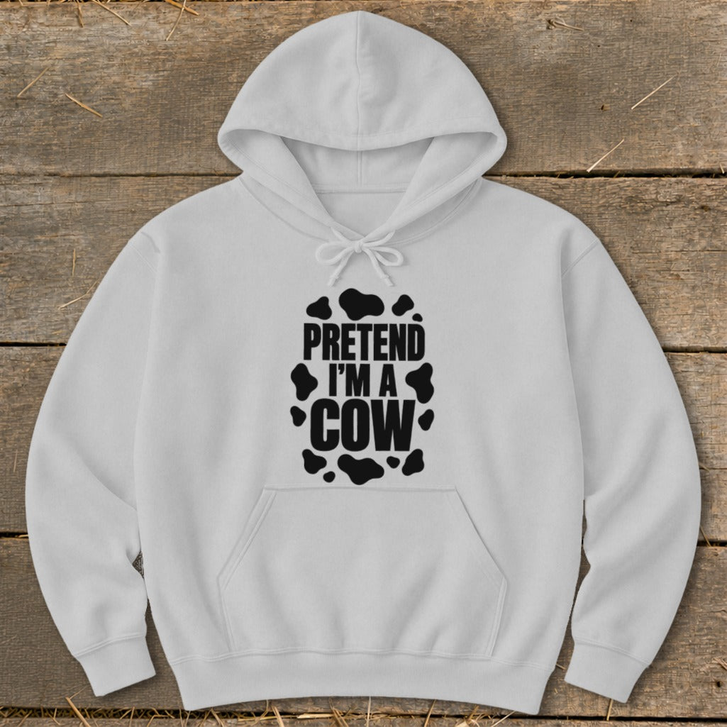 White hoodie with black "PRETEND I'M A COW" text and cow spots.