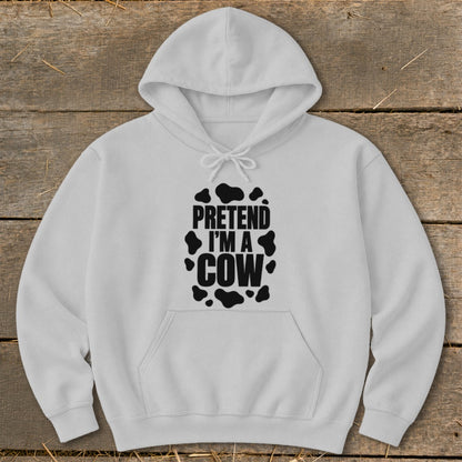 White hoodie with black "PRETEND I'M A COW" text and cow spots.