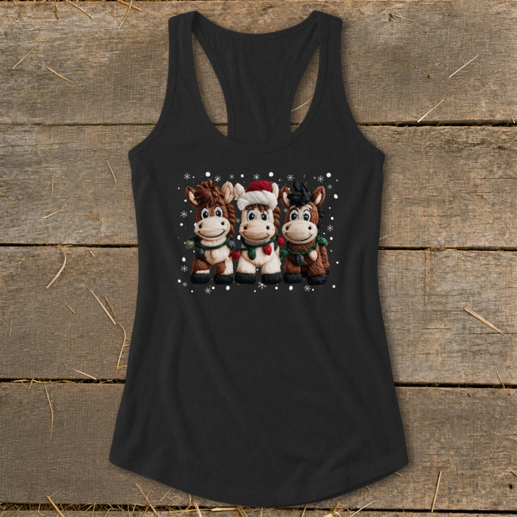 Three cartoon horses wearing Christmas scarves and snowflakes on a black tank top.