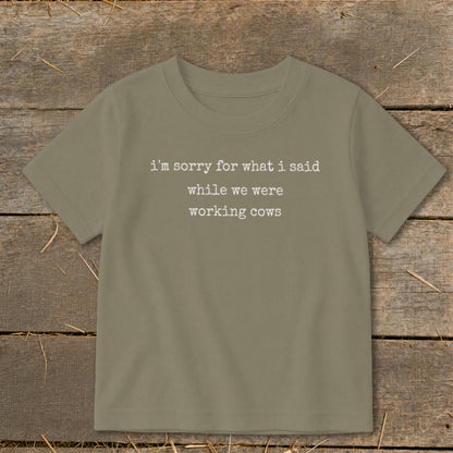 Olive green t-shirt with white text that says "i'm sorry for what i said while we were working cows".
