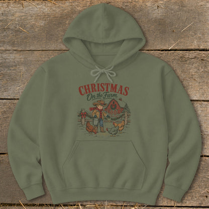 Green hoodie with "Christmas On the Farm" graphic of a child feeding chickens near a barn.