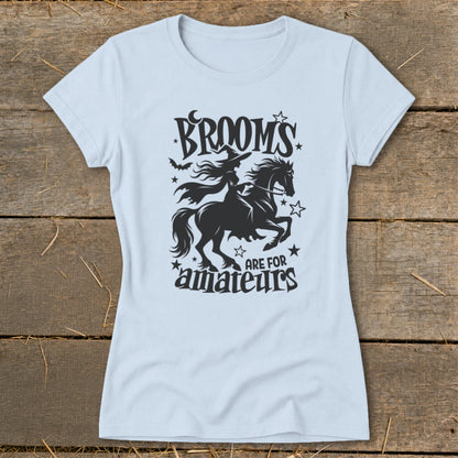 Light blue t-shirt with "Brooms are for amateurs" witch and horse graphic.