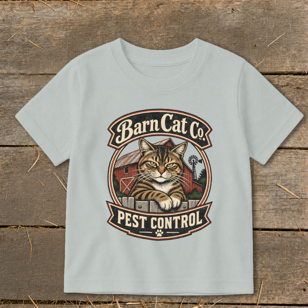 Light gray t-shirt with a vintage Barn Cat Co Pest Control graphic on a wooden background.