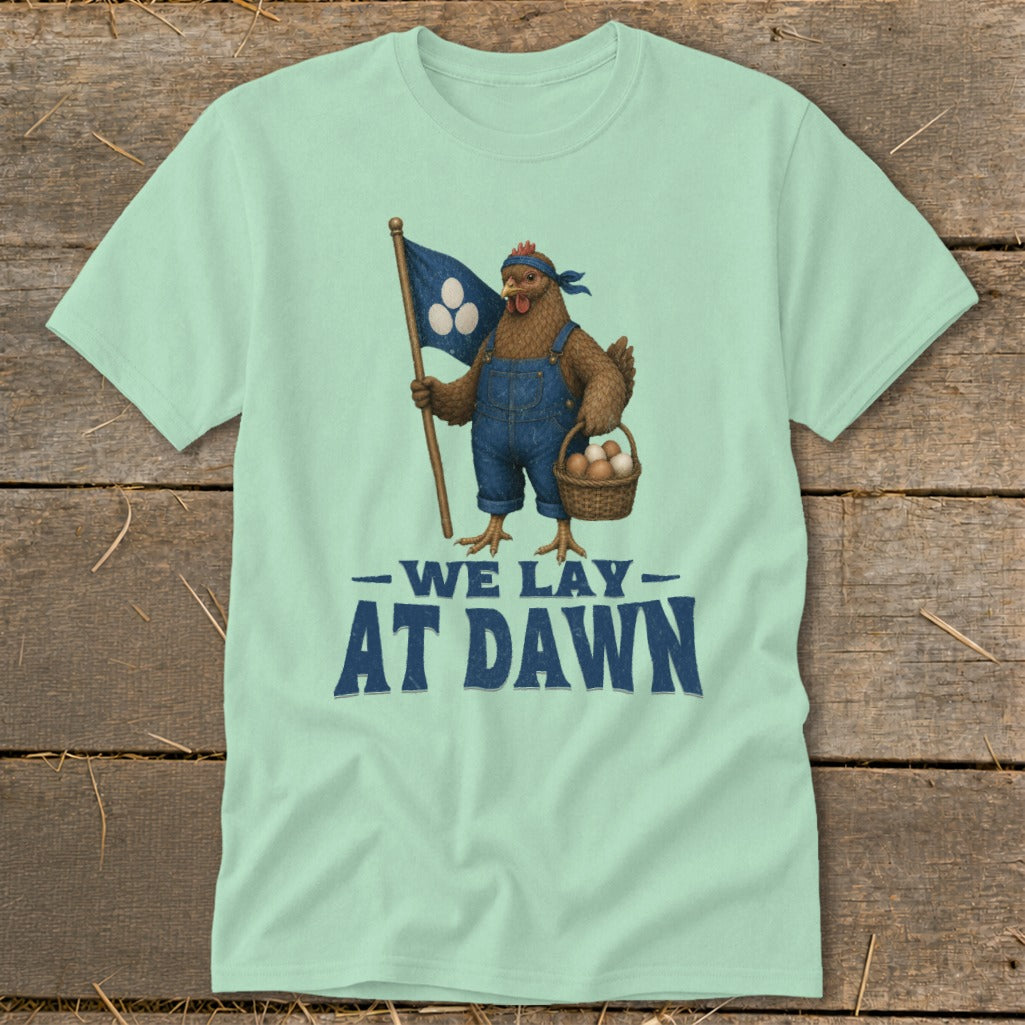 Chicken in overalls holds flag and basket of eggs, text reads "WE LAY AT DAWN".