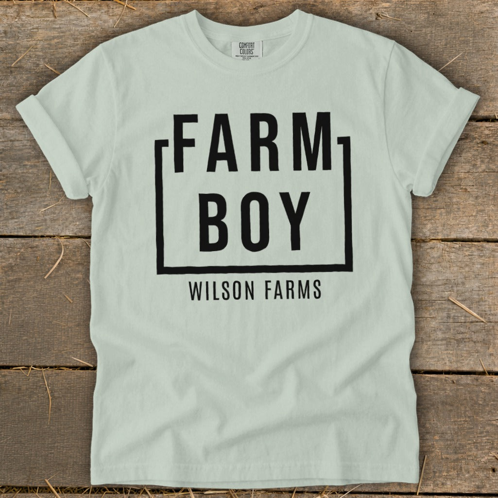 Light green t-shirt with black text "FARM BOY WILSON FARMS" within a box.
