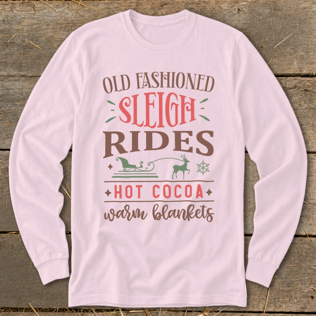 Pink long-sleeve shirt with "Old Fashioned Sleigh Rides Hot Cocoa Warm Blankets" text and graphics.