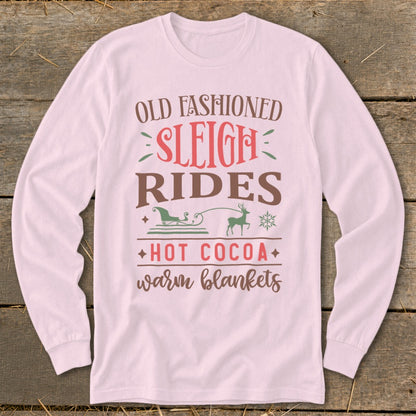 Pink long-sleeve shirt with "Old Fashioned Sleigh Rides Hot Cocoa Warm Blankets" text and graphics.