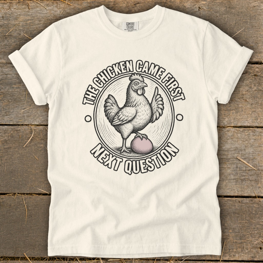 White t-shirt with a chicken and egg graphic, saying "The chicken came first. Next question."
