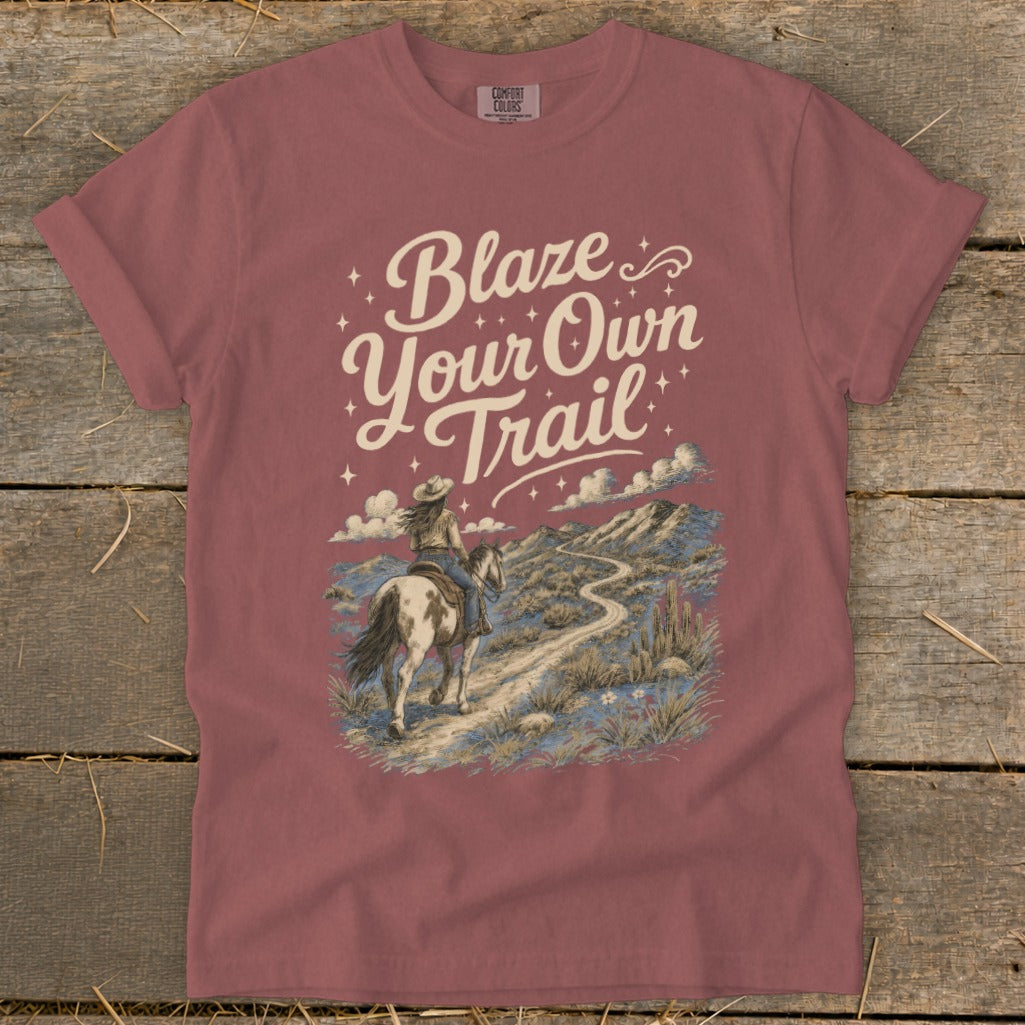 Rose colored t-shirt with "Blaze Your Own Trail" text and a desert landscape with a rider on horseback.