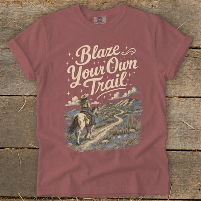 Rose colored t-shirt with "Blaze Your Own Trail" text and a desert landscape with a rider on horseback.
