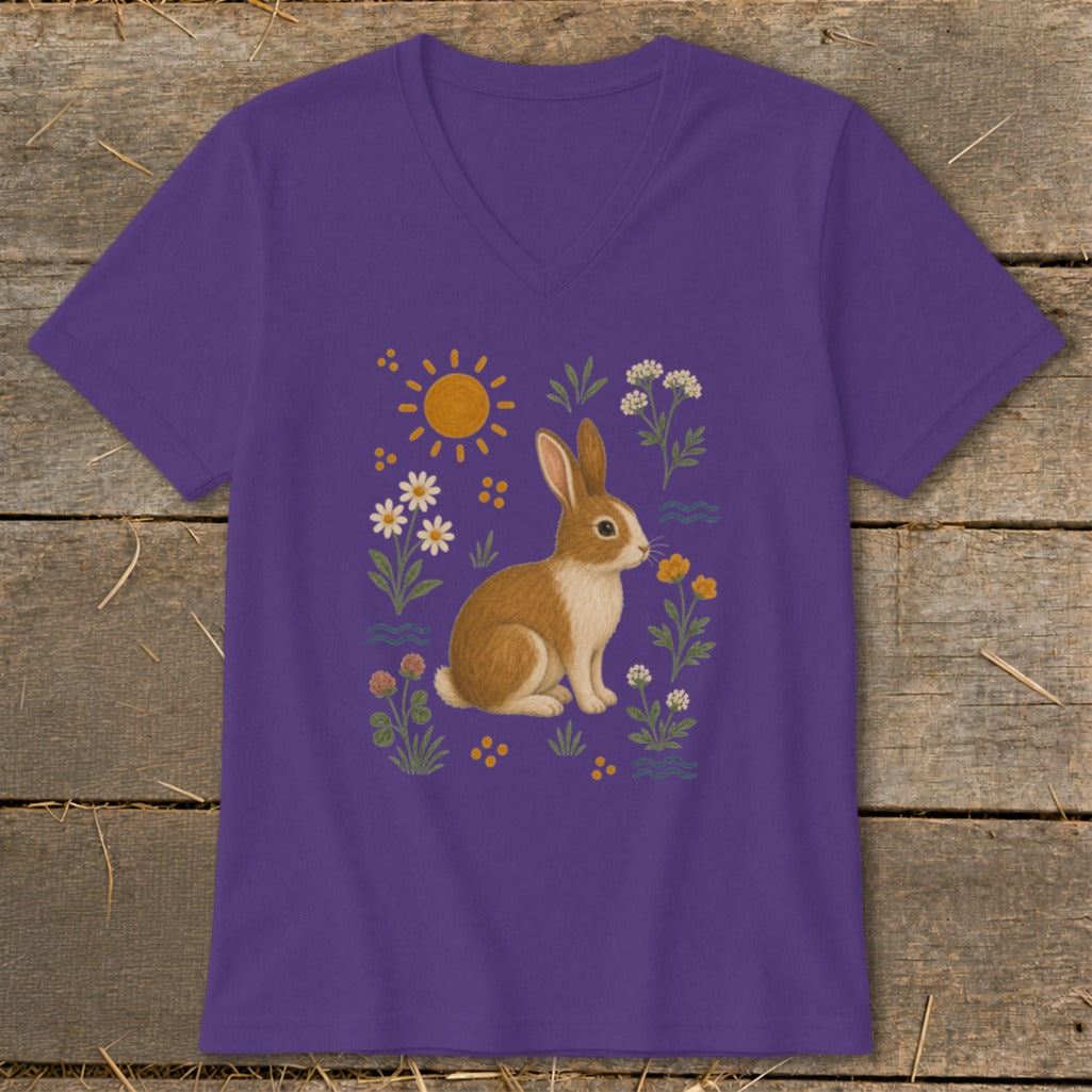 Purple t-shirt with brown and white rabbit smelling flowers and sun.