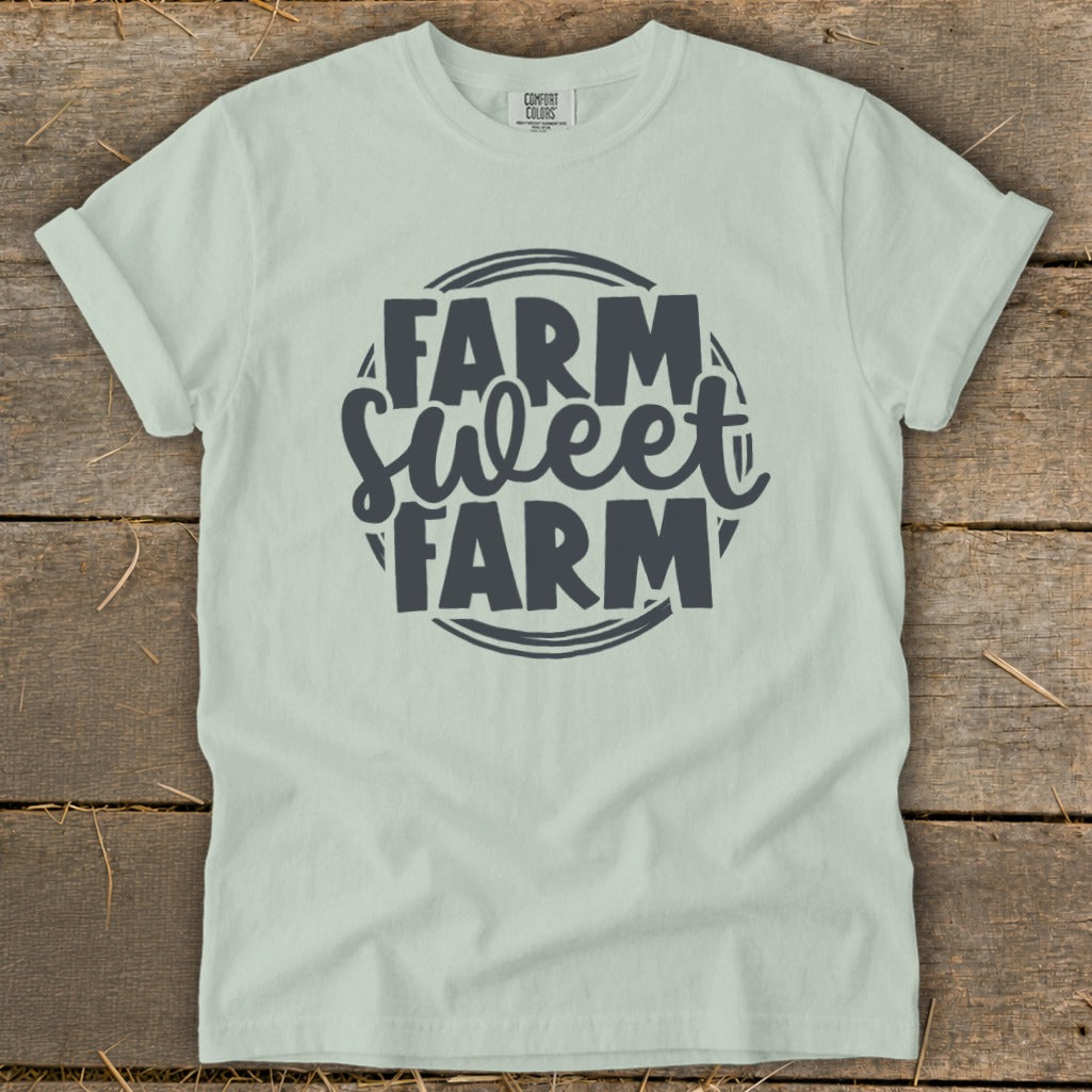 Light green t-shirt with dark gray text reading "Farm Sweet Farm" inside a circular design.