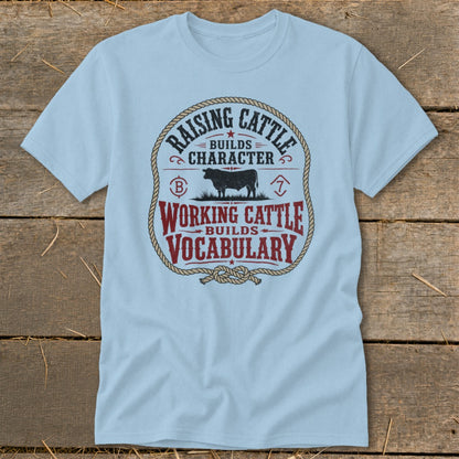 Light blue t-shirt with graphic: "Raising Cattle Builds Character. Working Cattle Builds Vocabulary."