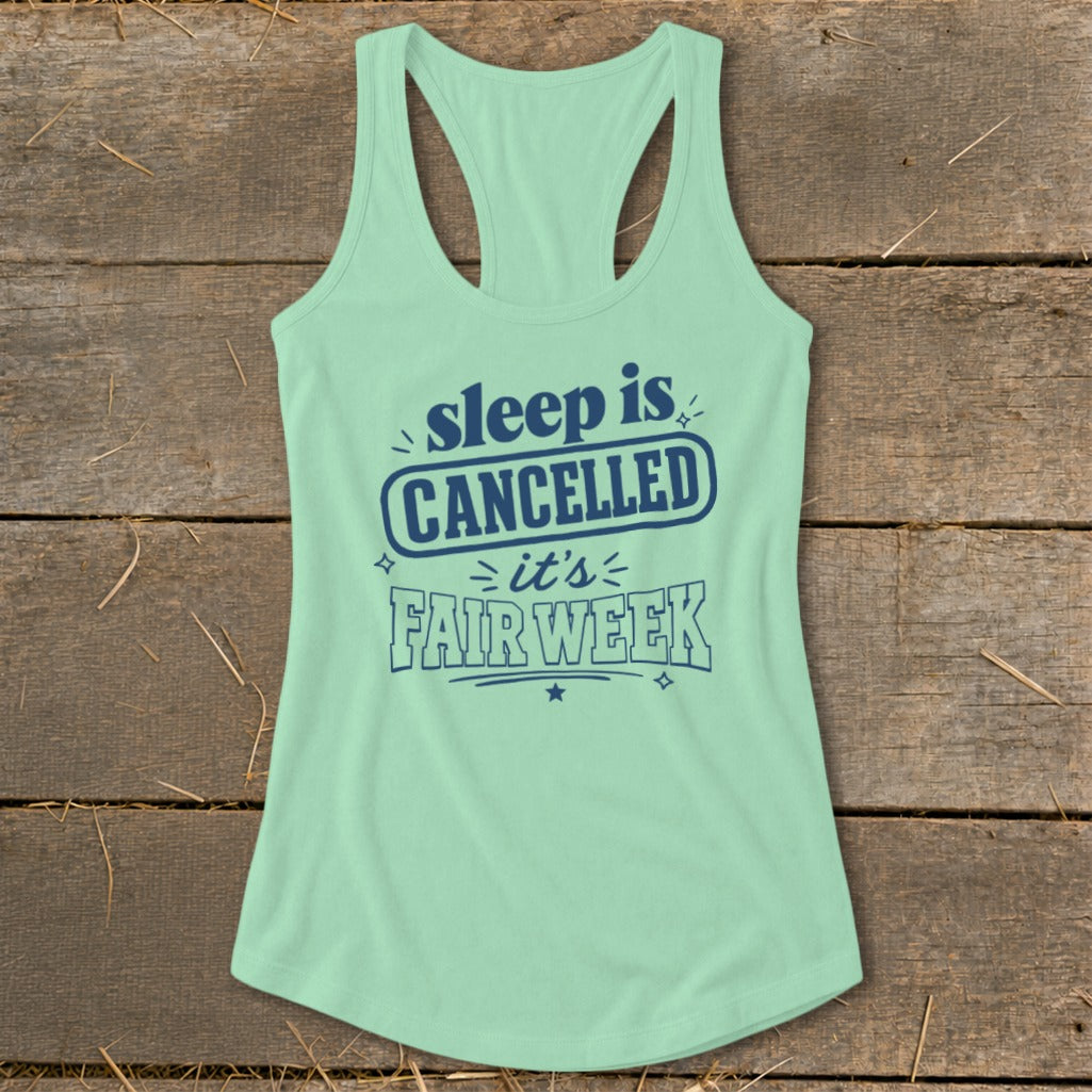 Mint green racerback tank top with navy text reading "sleep is CANCELLED it's FAIR WEEK".