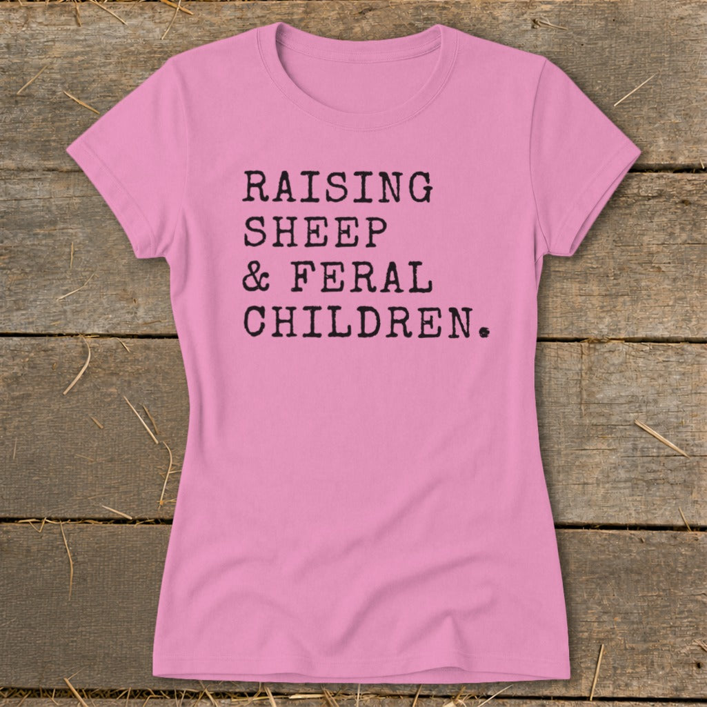 Pink t-shirt with black text reading "RAISING SHEEP & FERAL CHILDREN."