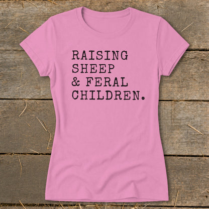 Pink t-shirt with black text reading "RAISING SHEEP & FERAL CHILDREN."