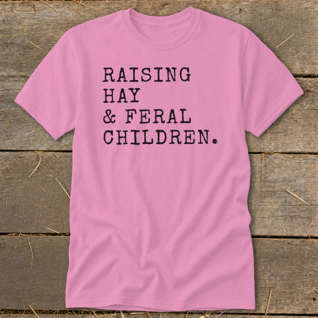 Pink t-shirt with black text reading "RAISING HAY & FERAL CHILDREN."