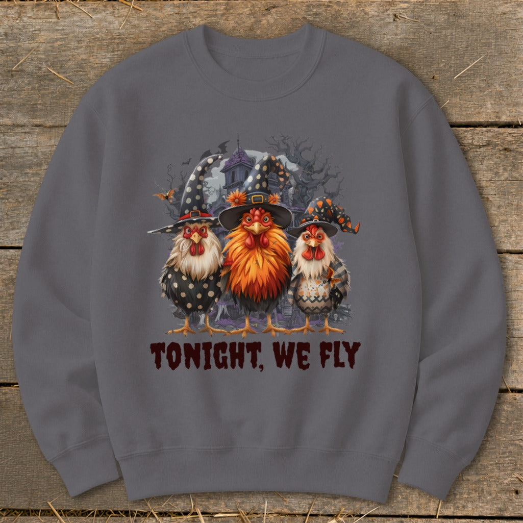 Three roosters in witch hats stand before a spooky house. "TONIGHT, WE FLY" text.
