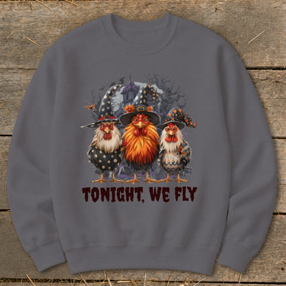 Three roosters in witch hats stand before a spooky house. "TONIGHT, WE FLY" text.