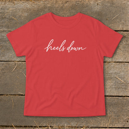Red t-shirt with white script text that reads "heels down".