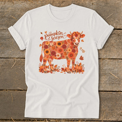 White t-shirt with a cow pattern of autumn flowers and leaves, text reads "Pumpkin season."