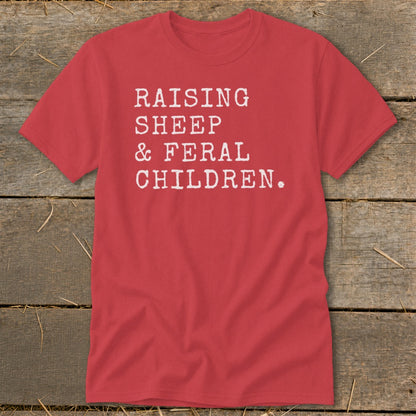 Red t-shirt with white text: "Raising Sheep & Feral Children."