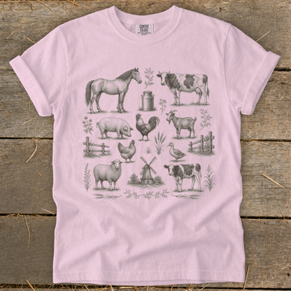 Pink t-shirt with a charcoal sketch of farm animals and a windmill.