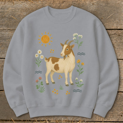 Light blue sweatshirt with a brown and white goat illustration surrounded by flowers and sun.