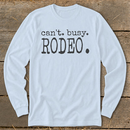 Light blue long sleeve shirt with "can't. busy. RODEO." text.