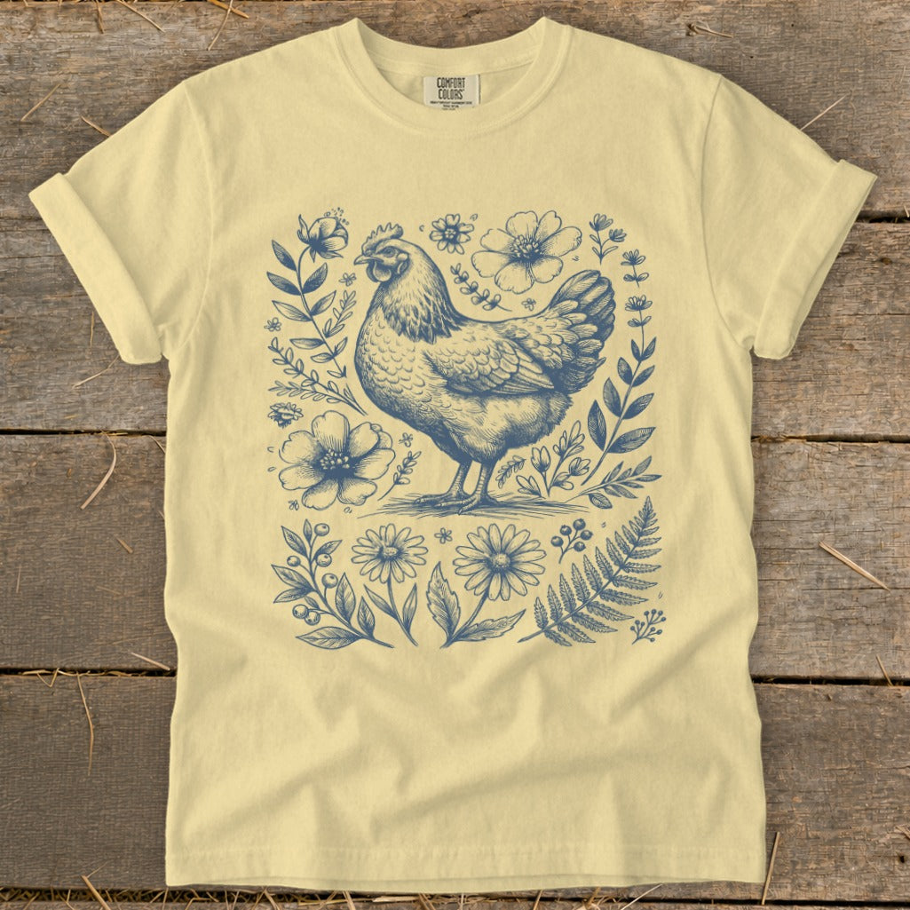 Light yellow t-shirt with a blue chicken and floral sketch print.