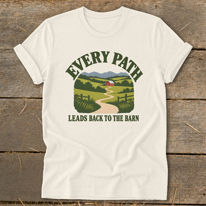 Cream t-shirt with a graphic of a winding path leading to a barn in a pastoral landscape. Text reads: "Every Path Leads Back to the Barn".